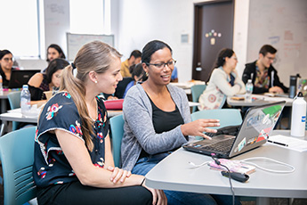 Two students looking at the computer screen